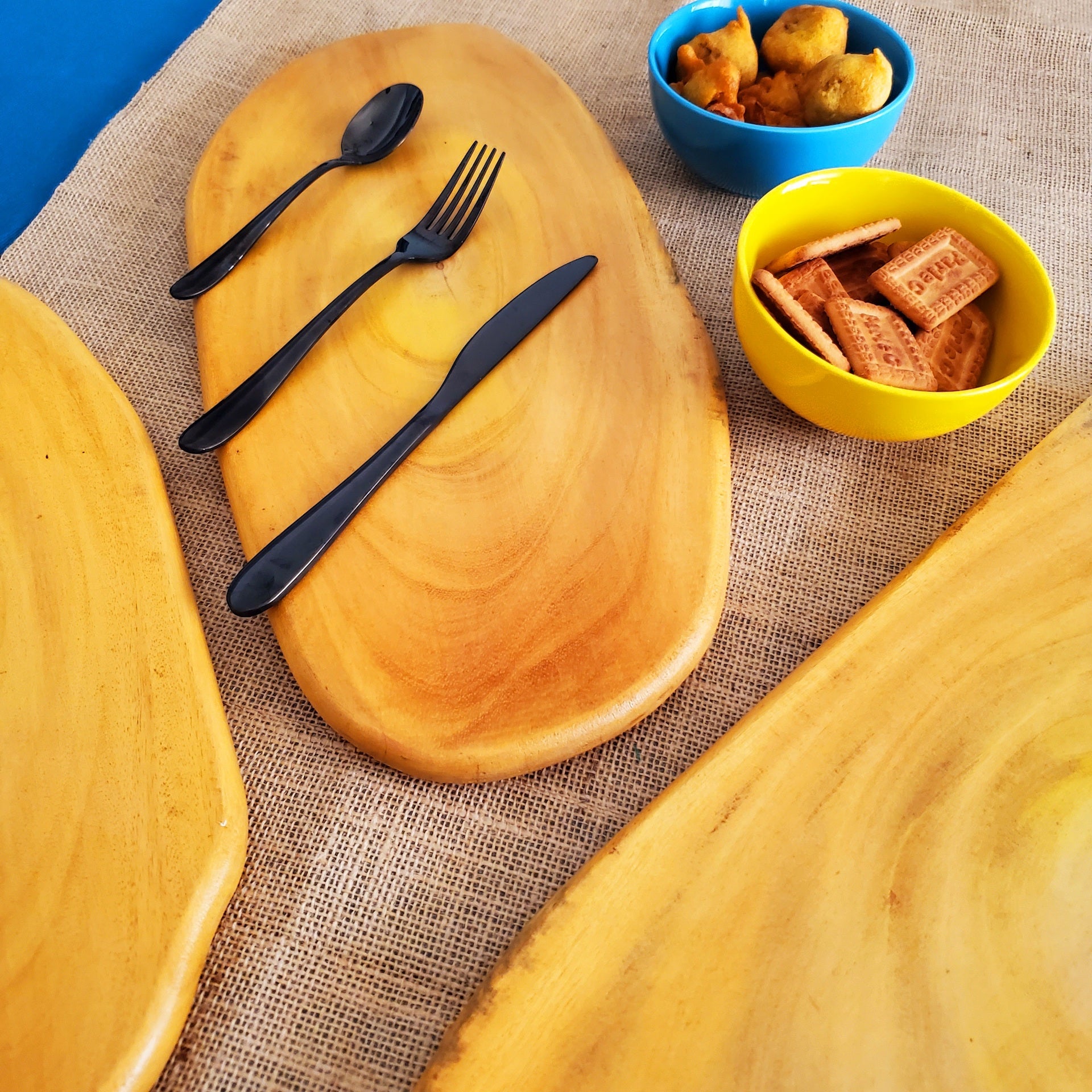 Beautifully Handcrafted food platter shaped like a flat pebble made out of Natural Solid Wood can be used to serve fruits, desserts, or snacks, burgers or sandwiches. The golden yellow color of the wood is so attractive and looks great when placed as a table topper to hold candle holders or flower vase.Perfect gifting idea for the festive season Diwali/ Deepavali, Navratri, Durga Puja, Christmas, other festivals. 